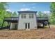 Back exterior of home with a black deck and rails, set against a backdrop of lush greenery at 827 Holly Rdg, Canton, GA 30115