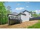 Back of house exterior featuring a black deck, white siding, dark roof, and landscaping at 827 Holly Rdg, Canton, GA 30115