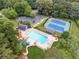 Aerial view of a community pool, tennis courts, clubhouse, and parking surrounded by trees at 827 Holly Rdg, Canton, GA 30115
