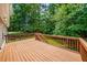 Wide back deck with wooden railings overlooking a lush, green backyard and mature trees at 1275 Kelly Nelson Dr, Lawrenceville, GA 30043