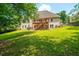 Expansive backyard featuring a two-story deck, lush lawn, and mature trees, perfect for outdoor entertaining and recreation at 1275 Kelly Nelson Dr, Lawrenceville, GA 30043
