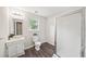 Bathroom featuring a white vanity, toilet, and a glass-enclosed shower, complemented by wood-style flooring at 1275 Kelly Nelson Dr, Lawrenceville, GA 30043