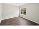 Bedroom featuring neutral paint, wood-look floors, and a window overlooking backyard at 1275 Kelly Nelson Dr, Lawrenceville, GA 30043