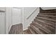 Hallway with carpeted stairs and wood-style floors near a white door and coat hooks at 1275 Kelly Nelson Dr, Lawrenceville, GA 30043