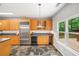 Updated kitchen with stainless steel appliances, granite counters, wine cooler, and backyard views at 1275 Kelly Nelson Dr, Lawrenceville, GA 30043