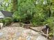 Picturesque backyard featuring a stone patio with dining area, a tranquil water feature, and lush landscaping at 2054 Palifox Ne Dr, Atlanta, GA 30307