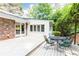 Backyard featuring a white deck with outdoor dining set, brick and white siding, and lush green scenery at 2197 Fairway Ne Cir, Brookhaven, GA 30319