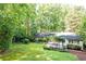 Extensive backyard with mature trees, a deck with outdoor dining set, and lush green lawns at 2197 Fairway Ne Cir, Brookhaven, GA 30319