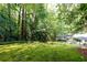 Lush backyard featuring mature trees and a charming patio area, perfect for relaxation and outdoor gatherings at 2197 Fairway Ne Cir, Brookhaven, GA 30319