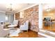 Sitting area showcasing wood floors, exposed brick, and an open doorway leading to dining room at 2197 Fairway Ne Cir, Brookhaven, GA 30319