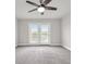 This bedroom features carpet, a ceiling fan, and a glass door to a balcony at 2340 Manor Pointe Dr, Cumming, GA 30041