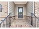 Inviting front porch with brick flooring, a gray front door, and decorative address at 2340 Manor Pointe Dr, Cumming, GA 30041