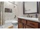 Bathroom features white cabinets, dual vanity, and a shower with decorative tile at 241 Russell Rd, Lawrenceville, GA 30043