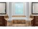 This elegant bathroom has a large tub with custom tile surround and two vanities at 241 Russell Rd, Lawrenceville, GA 30043