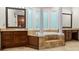 This large bathroom boasts dual vanities, a large tub and travertine tile at 241 Russell Rd, Lawrenceville, GA 30043