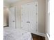 Bright bedroom with hardwood floors, a large window with blinds, and a comfortable bed at 241 Russell Rd, Lawrenceville, GA 30043