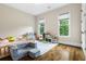 This bright bedroom has hardwood floors, two large windows and a comfortable chair at 241 Russell Rd, Lawrenceville, GA 30043
