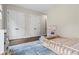 Bright bedroom with wooden floors, a blue rug and two closets with white doors at 241 Russell Rd, Lawrenceville, GA 30043