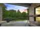 Relax on the covered deck with a swing, grill, and wooded views providing a peaceful outdoor experience at 241 Russell Rd, Lawrenceville, GA 30043