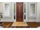 Beautiful entryway with custom wood door, transom window, sidelights, shutters, and hardwood floors at 241 Russell Rd, Lawrenceville, GA 30043