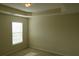 This bedroom has neutral walls, neutral carpeting, and a window with blinds at 804 Bridle Cove, Stockbridge, GA 30281