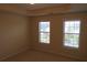 This bedroom has neutral walls, neutral carpeting, and two windows with blinds at 804 Bridle Cove, Stockbridge, GA 30281