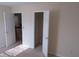 A sunlit bedroom with neutral walls and carpet, offering a view to the stairs and closet at 804 Bridle Cove, Stockbridge, GA 30281