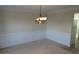 Dining room featuring wainscoting and a modern chandelier at 804 Bridle Cove, Stockbridge, GA 30281