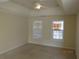 Main bedroom featuring a tray ceiling, neutral carpet, and bright windows at 804 Bridle Cove, Stockbridge, GA 30281