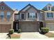 Two-story townhouse with a two-car garage, neat landscaping, and stone and siding exterior at 2351 Attewood Dr, Buford, GA 30519