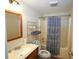 Well-lit bathroom features a shower-tub combo, vanity with storage, and a decorative blue patterned shower curtain at 236 Hiram Sudie Rd, Dallas, GA 30157