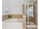 Bathroom with a tub and shower tiled with beige square tiles at 2840 Brookford Sw Ln, Atlanta, GA 30331