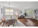 Open-concept living room with hardwood floors, dining table, sofa, and bright natural light at 2840 Brookford Sw Ln, Atlanta, GA 30331