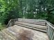 View of a wooden deck with built in bench surrounded by trees at 134 Summer Lake Dr, Dallas, GA 30157
