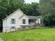 Charming home featuring light siding, light shutters, lush greenery, and a convenient ramp to the front door at 134 Summer Lake Dr, Dallas, GA 30157