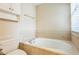Bright bathroom with a tub showcasing neutral tile, a tiled wall and a window at 1666 Oakbrook Lake Dr, Norcross, GA 30093