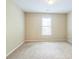 A spacious bedroom with neutral carpet and a sunny window at 1666 Oakbrook Lake Dr, Norcross, GA 30093