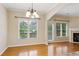 Dining area features hardwood floors, large windows, and a view of the living room fireplace at 1666 Oakbrook Lake Dr, Norcross, GA 30093