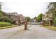 Gated community entrance with brick pillars, a wrought iron gate, and landscaped surroundings at 1666 Oakbrook Lake Dr, Norcross, GA 30093