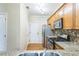 Well-lit kitchen features wood cabinets, stainless steel appliances, granite countertops, and access to the backdoor at 1666 Oakbrook Lake Dr, Norcross, GA 30093