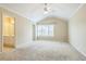 A spacious main bedroom with large window, ceiling fan, neutral walls, and attached bathroom at 1666 Oakbrook Lake Dr, Norcross, GA 30093
