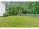 Spacious backyard with lush green grass, wooden fence, and a playground for to enjoy at 2750 Briarfield Way, Lawrenceville, GA 30043