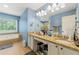 Bathroom with natural light, granite countertops, dual vanity sink, and soaking tub at 2750 Briarfield Way, Lawrenceville, GA 30043