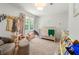 Comfortable bedroom featuring natural light, carpeted floor, seating area and crib at 2750 Briarfield Way, Lawrenceville, GA 30043