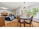 Open dining area featuring a modern chandelier, table with seating, and view into the living room at 2750 Briarfield Way, Lawrenceville, GA 30043