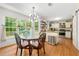 Bright dining area with a modern light fixture, glass table, and views of the backyard at 2750 Briarfield Way, Lawrenceville, GA 30043