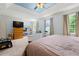 Spacious bedroom featuring natural light, tray ceiling with ceiling fan, and large windows at 2750 Briarfield Way, Lawrenceville, GA 30043