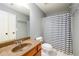 Bathroom featuring single vanity with granite counter and gray and white striped shower curtain at 4916 Gathering Pl, Suwanee, GA 30024