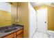 Bathroom with wooden vanity, granite countertop, decorative white shower curtain, and white-tiled floor at 4916 Gathering Pl, Suwanee, GA 30024