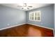 Well-lit bedroom with hard wood floors and white trim at 4916 Gathering Pl, Suwanee, GA 30024